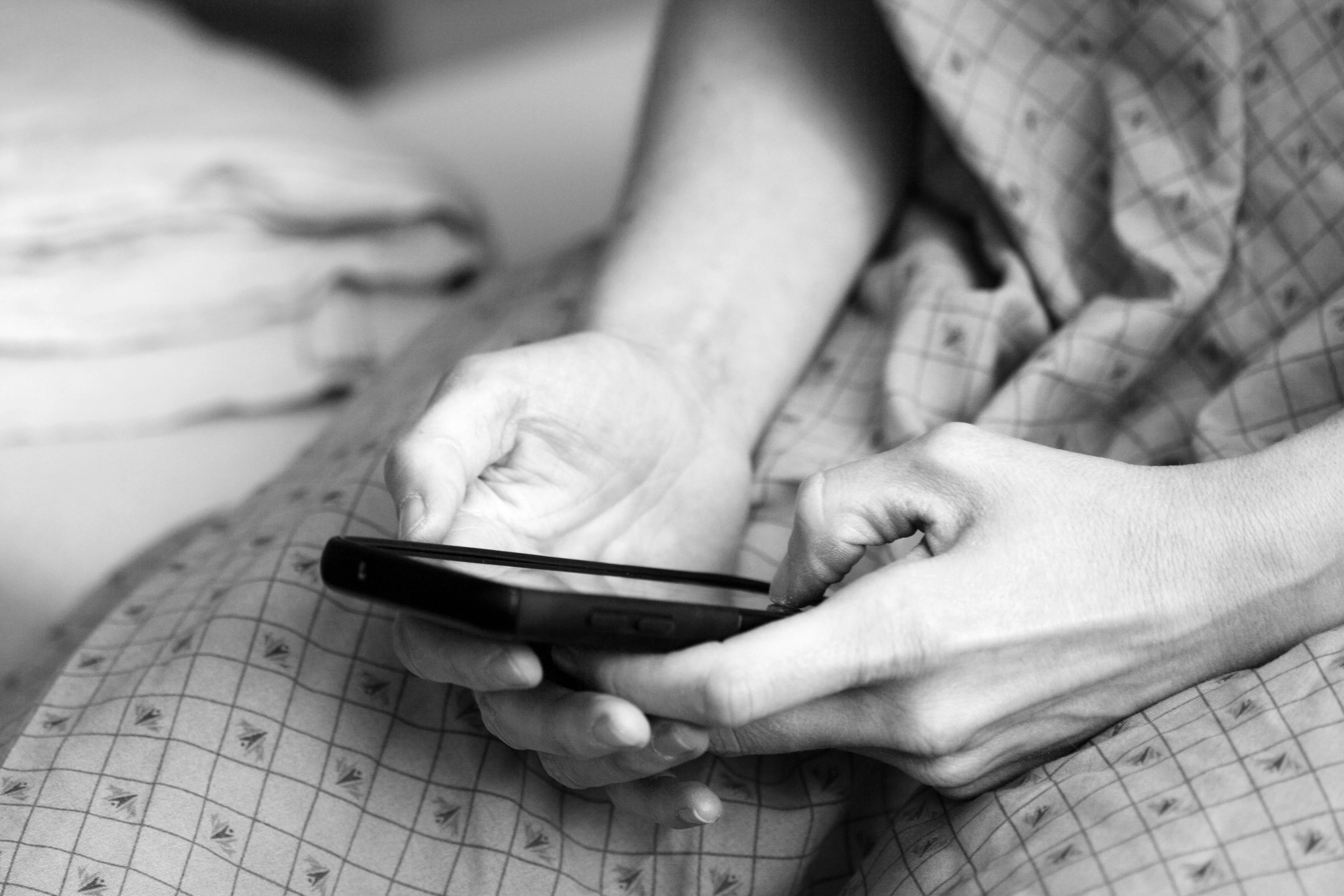 Kræftpatient ser på mobiltelefon.